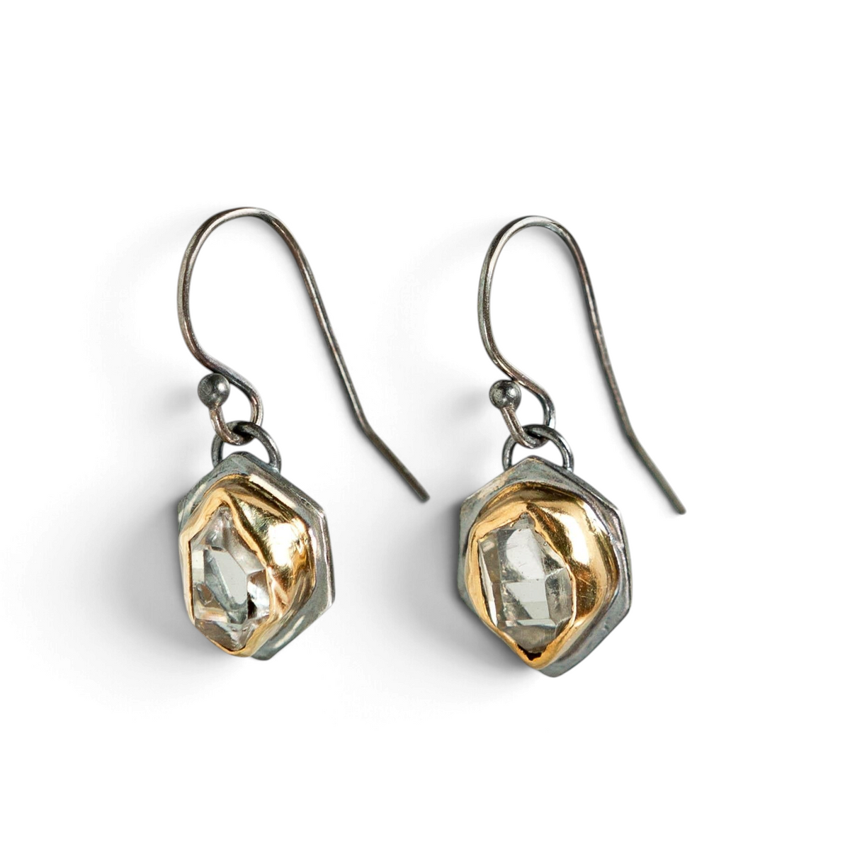 Stórica Studio Glacier drop earrings featuring raw Herkimer quartz crystals in two-toned gold and oxidized silver.