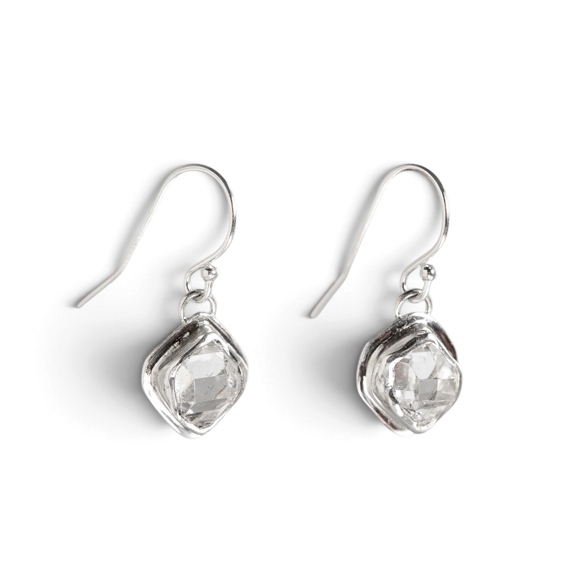 Stórica Studio Glacier drop earrings featuring raw Herkimer quartz crystals in minimal sterling silver bezel settings.