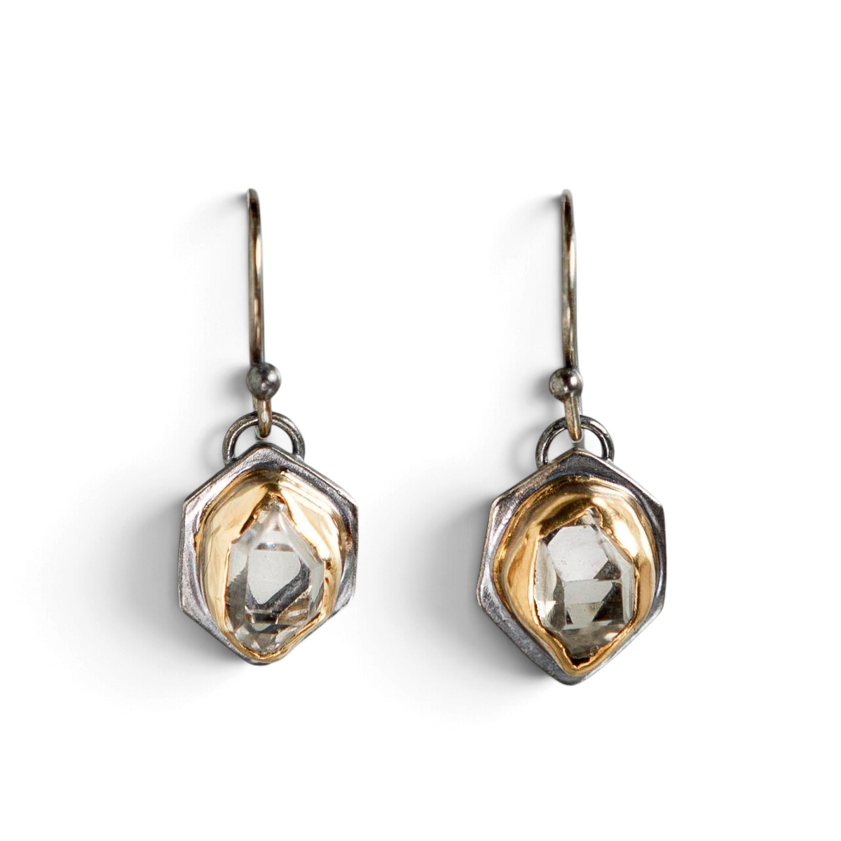 Stórica Studio Glacier drop earrings featuring raw Herkimer quartz crystals in two-toned gold and oxidized silver.