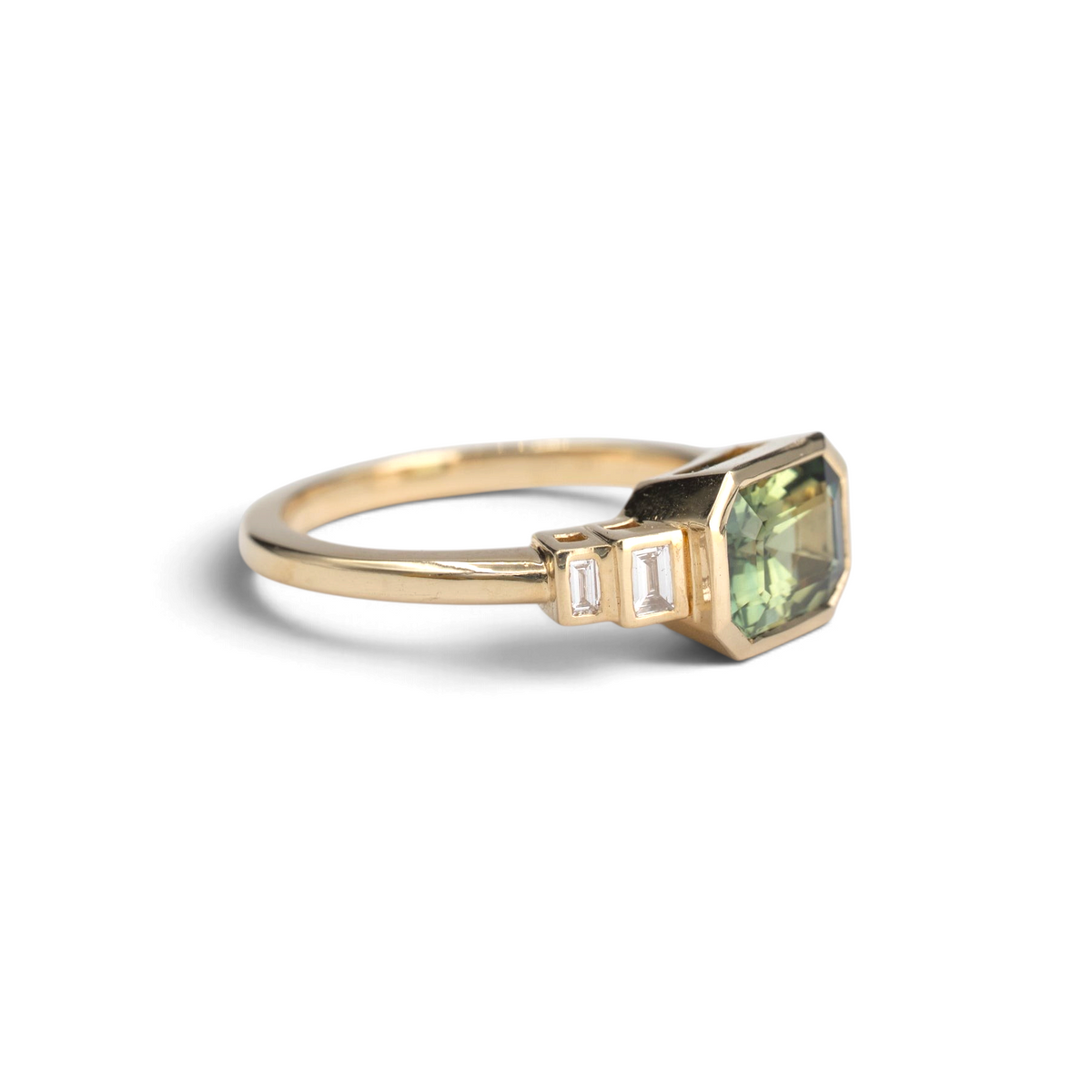 Stórica Studio 14k yellow gold ring featuring an emerald cut Australian sapphire and baguette diamond side stones.