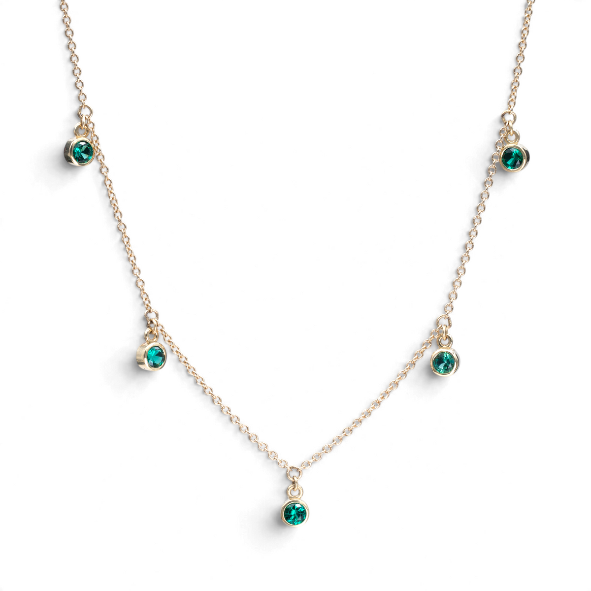 Stórica Studio Harbor Lights necklace featuring five bezel-set green birthstones on a delicate 14k gold cable chain.