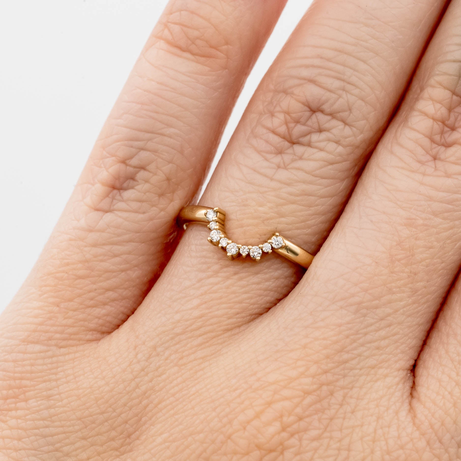 This beautiful, sparkling band features prong-set stones across a gentle curve that makes it perfectly stackable with most other rings. It would make a beautiful wedding or anniversary band, or a special treat for yourself.