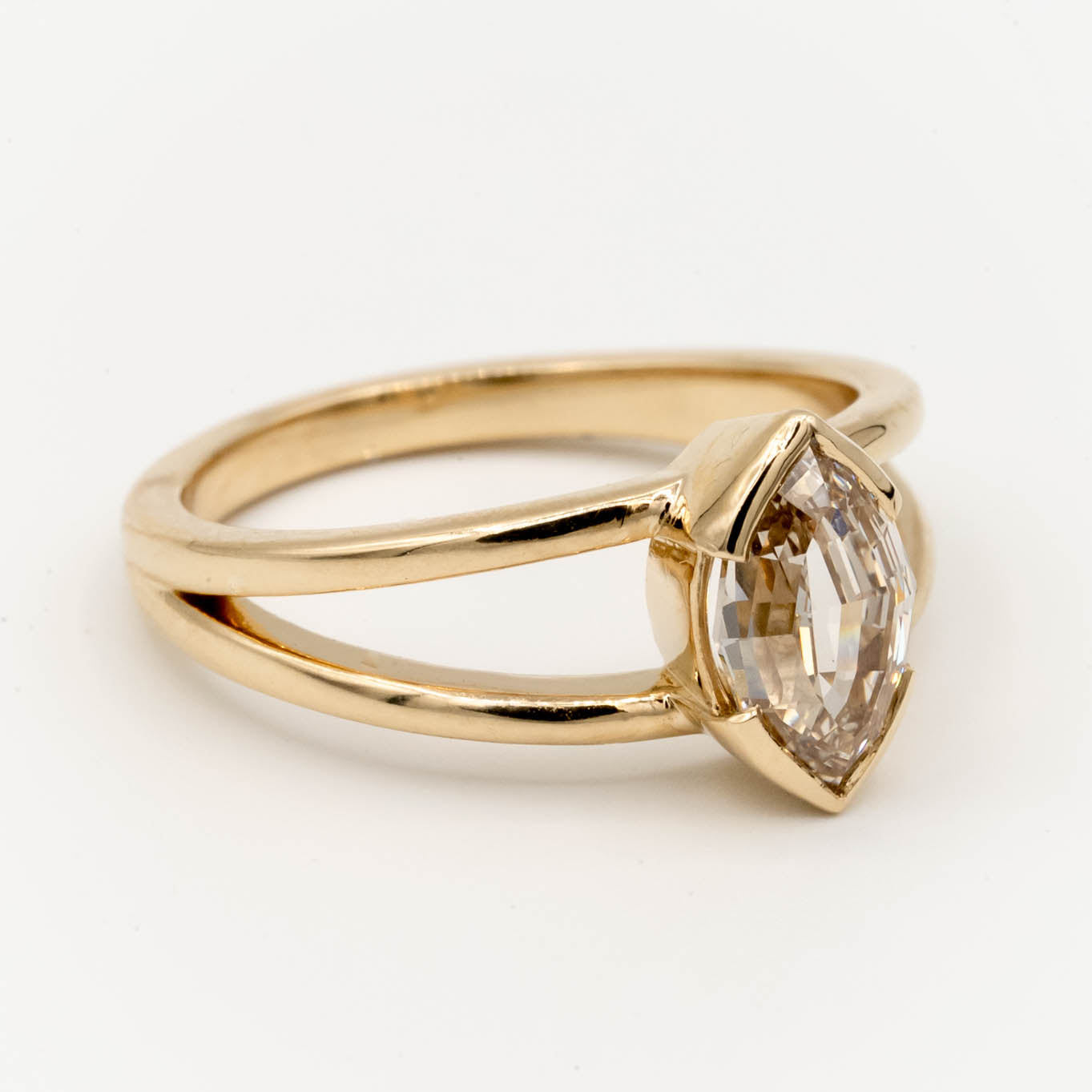 1.5ct Canadian-mined champagne diamond in a geometric marquise cut, set in a half-bezel Willow style double band, crafted in 14k yellow gold. Ethically sourced custom engagement ring from Seattle, WA.