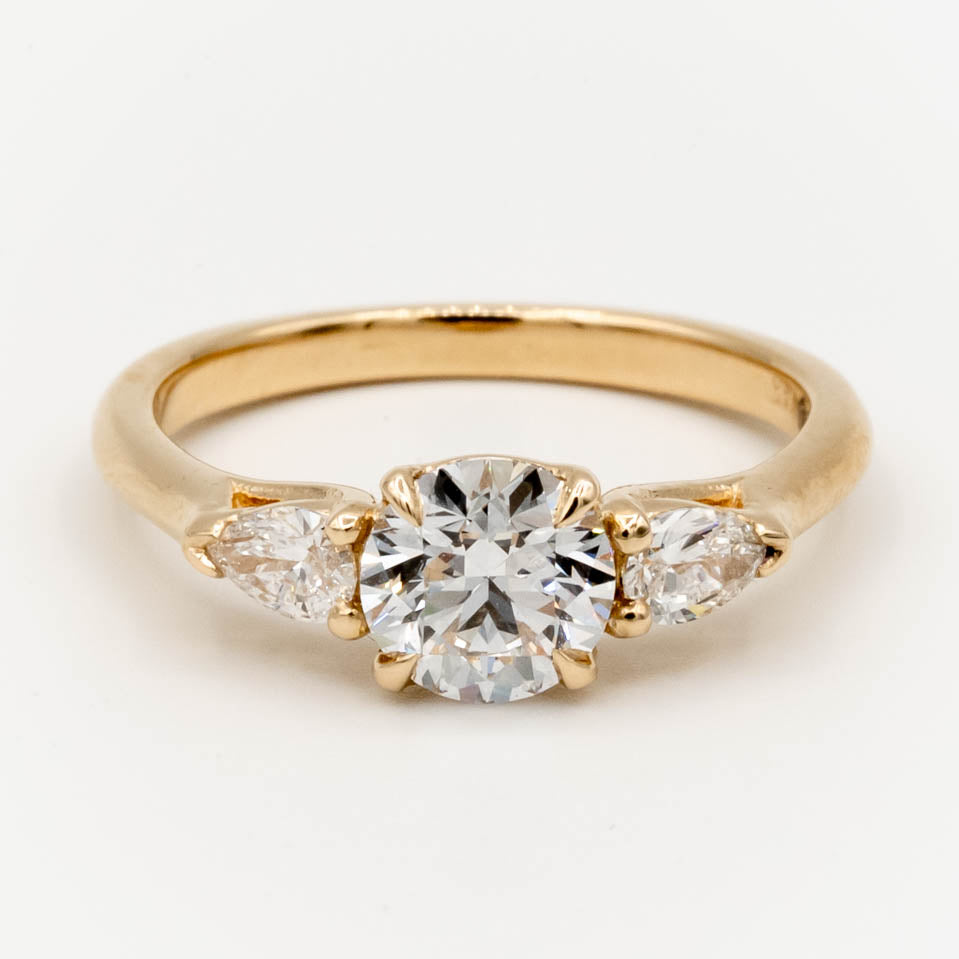 Storica’s classic 3-stone engagement ring featuring a 1 carat D color, VVS2 clarity lab-grown diamond center and pear-shaped lab-grown diamonds in a trellis setting, crafted in 14k yellow gold.
