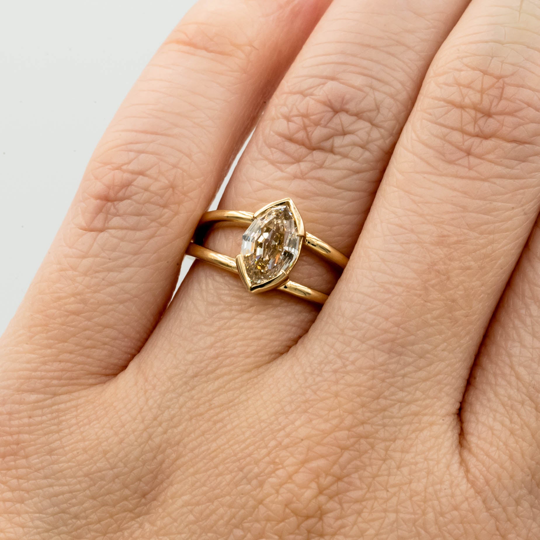 1.5ct Canadian-mined champagne diamond in a geometric marquise cut, set in a half-bezel Willow style double band, crafted in 14k yellow gold. Ethically sourced custom engagement ring from Seattle, WA.