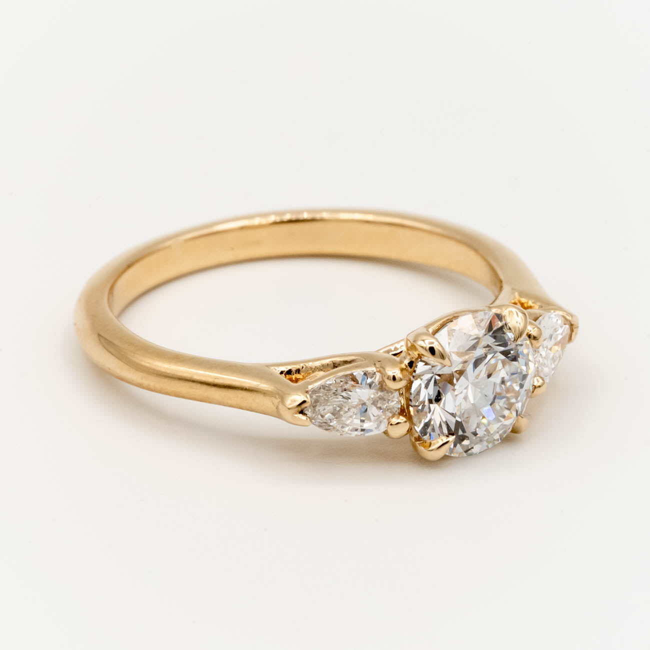 Storica’s classic 3-stone engagement ring featuring a 1 carat D color, VVS2 clarity lab-grown diamond center and pear-shaped lab-grown diamonds in a trellis setting, crafted in 14k yellow gold.