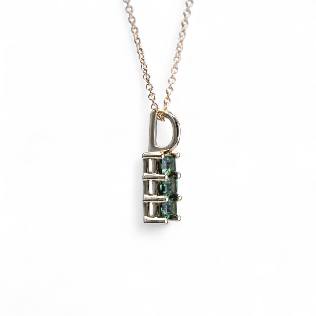 Fern charm with three emerald cut green sapphires in 14k yellow gold, side view