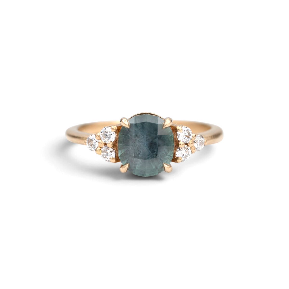 Stórica Studio The Holly ring featuring a 2.06ct oval Montana sapphire and round diamond side stones in 18k yellow gold