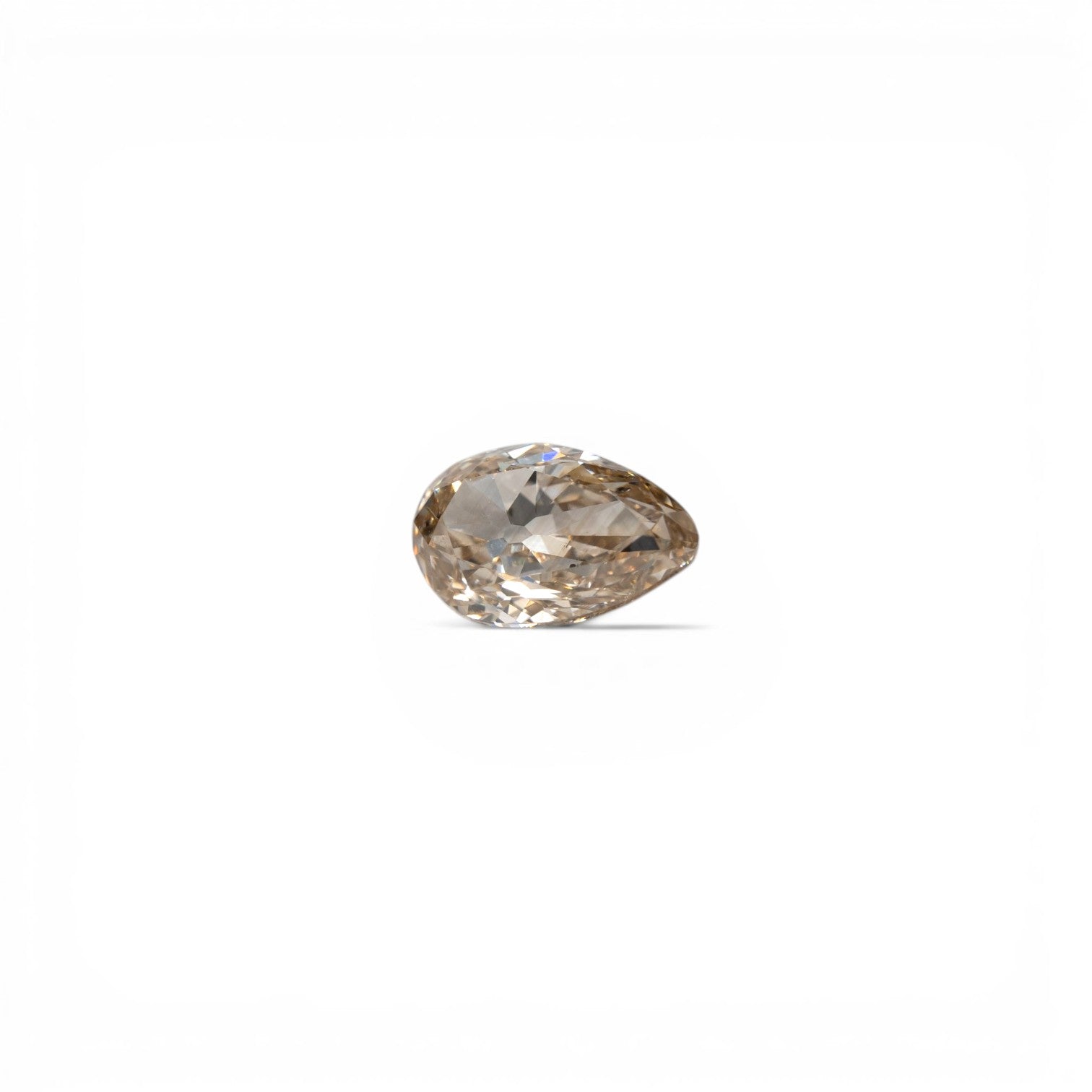 Stórica Studio custom engagement rings in Seattle, 1.11ct antique old mine cut pear diamond, fancy light brown, SI2 clarity, with warm toasty peachy-brown tones, photographed loose on a white background.