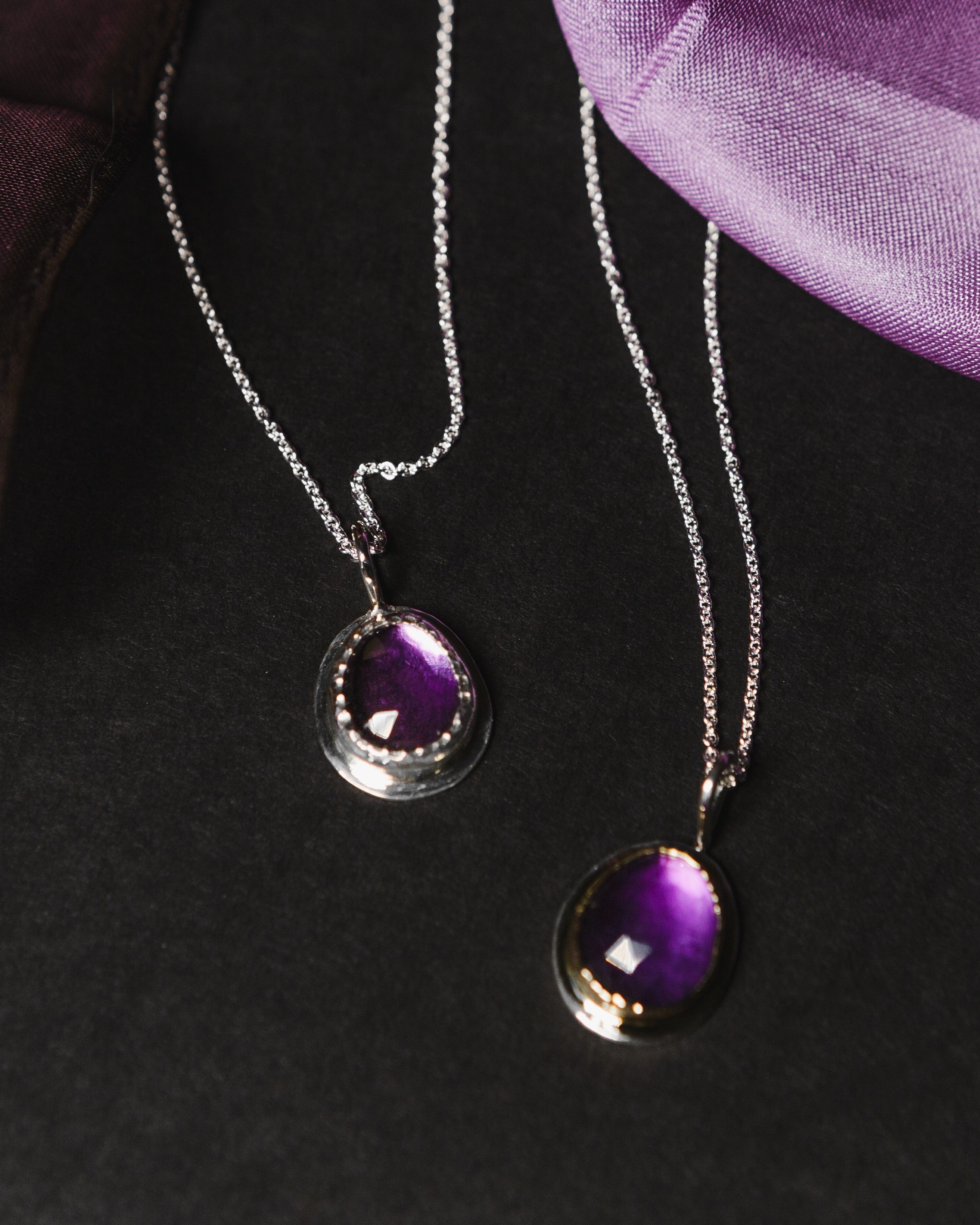 A sterling silver ring featuring 2 purple amethyst gemstones.