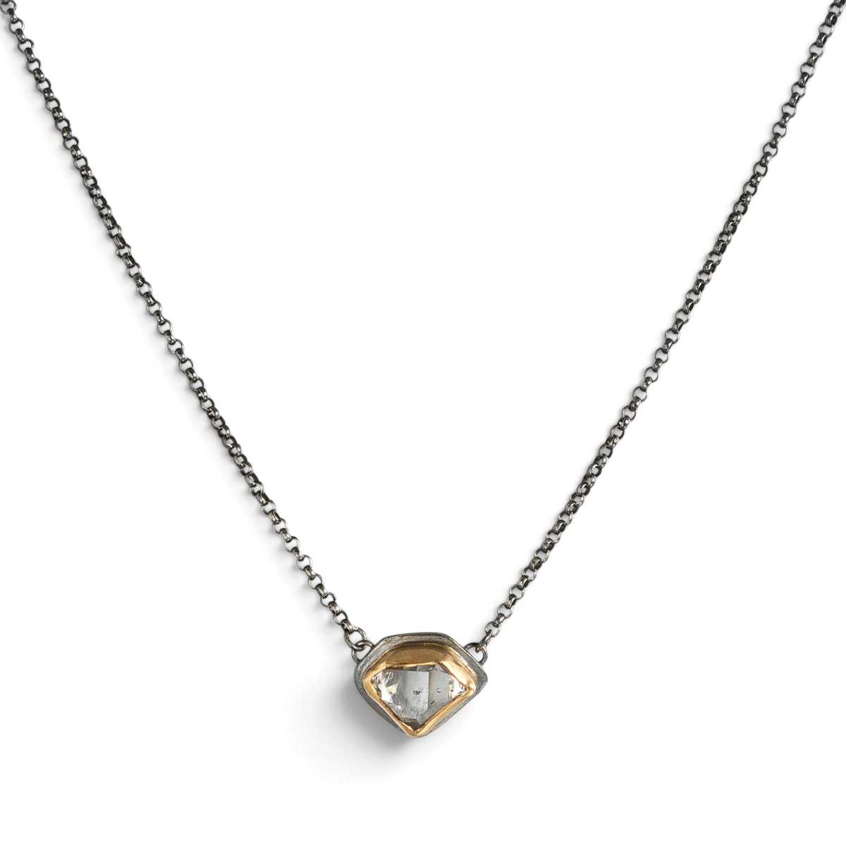 Stórica Studio East-West Glacier necklace featuring a raw Herkimer quartz crystal in a gold and oxidized silver setting.