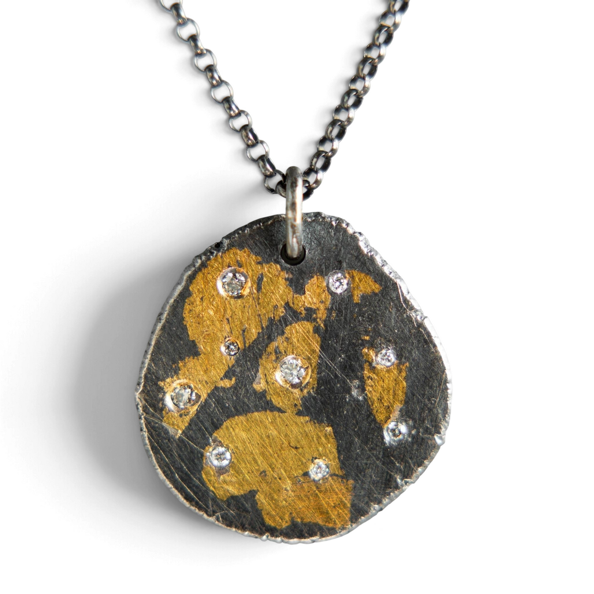 Stórica Studio Gilded Relic pendant in oxidized silver and 24k gold with diamond accents on a cable chain.