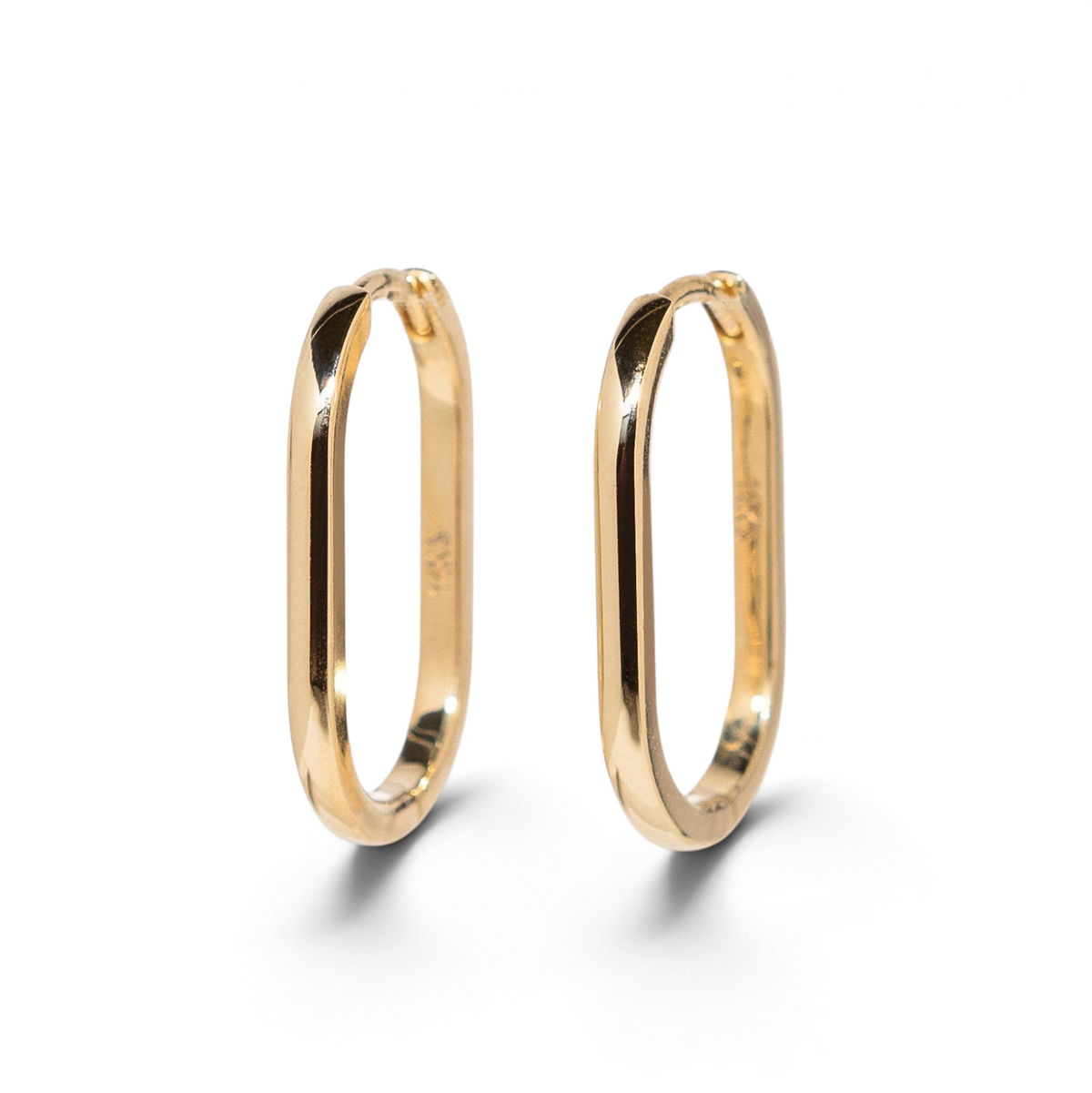 Stórica Studio Drift Hoops featuring solid polished yellow gold elongated oval huggie earrings with hinged closures.