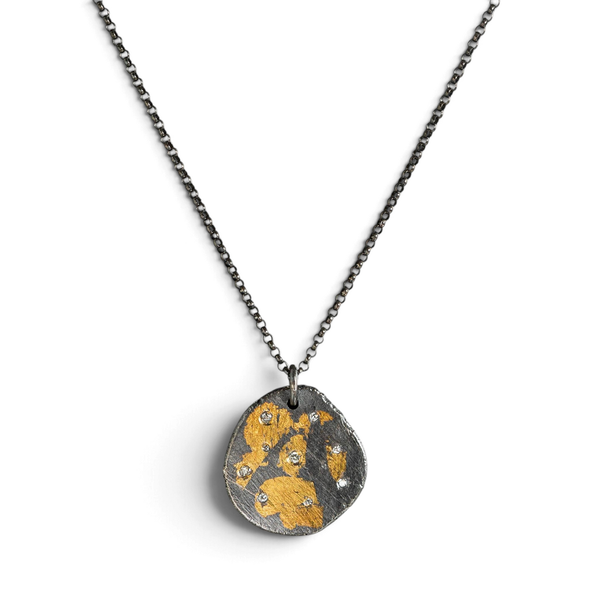 Stórica Studio Gilded Relic necklace featuring an oxidized silver pendant with 24k gold keum-boo and white diamonds.