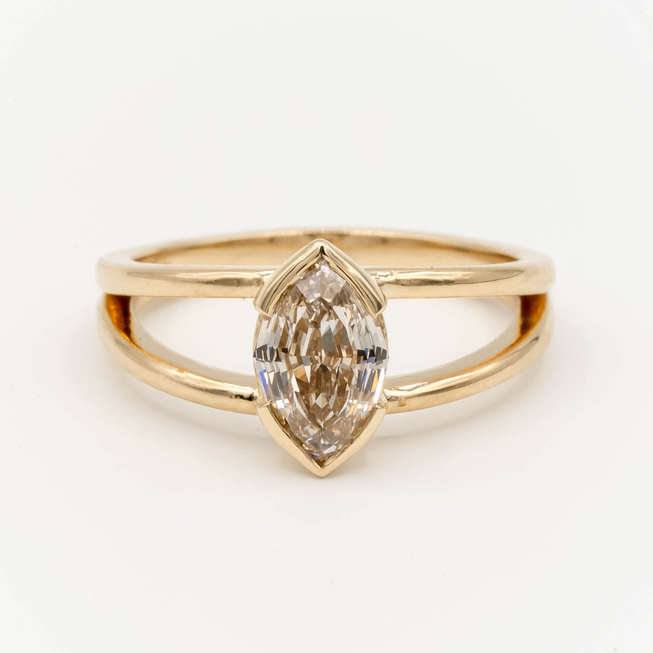 1.5ct Canadian-mined champagne diamond in a geometric marquise cut, set in a half-bezel Willow style double band, crafted in 14k yellow gold. Ethically sourced custom engagement ring from Seattle, WA.