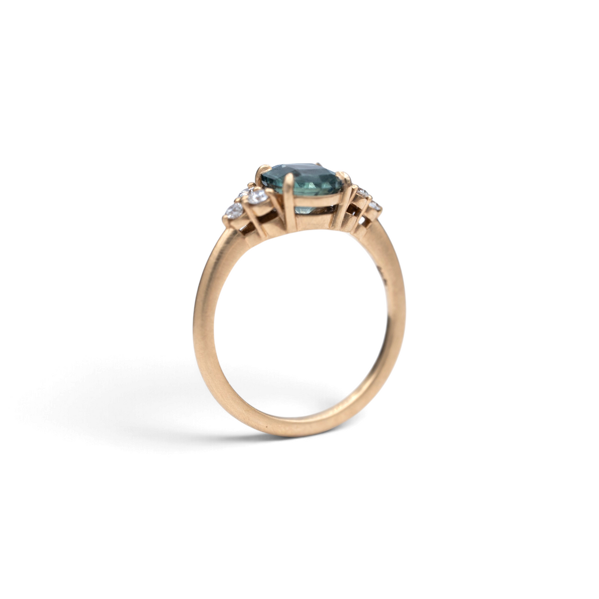 Stórica Studio The Holly ring with a 2.06ct oval Montana sapphire and diamond side stones in 18k yellow gold
