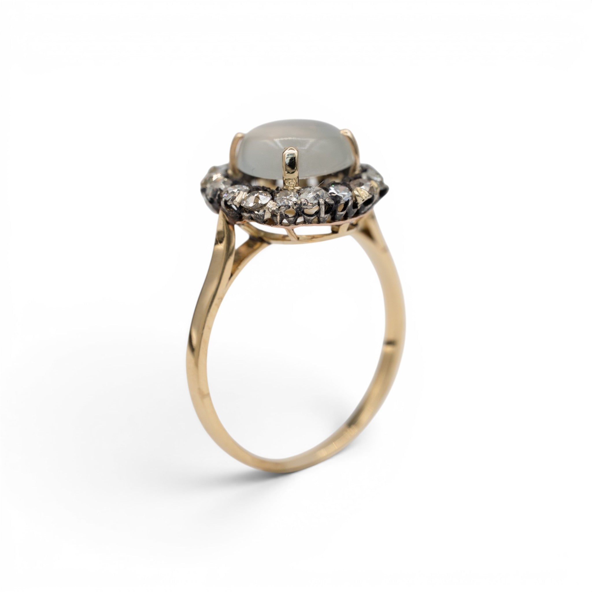 Stórica Studio moonstone halo ring featuring a cabochon moonstone surrounded by diamonds in 14k yellow and white gold.
