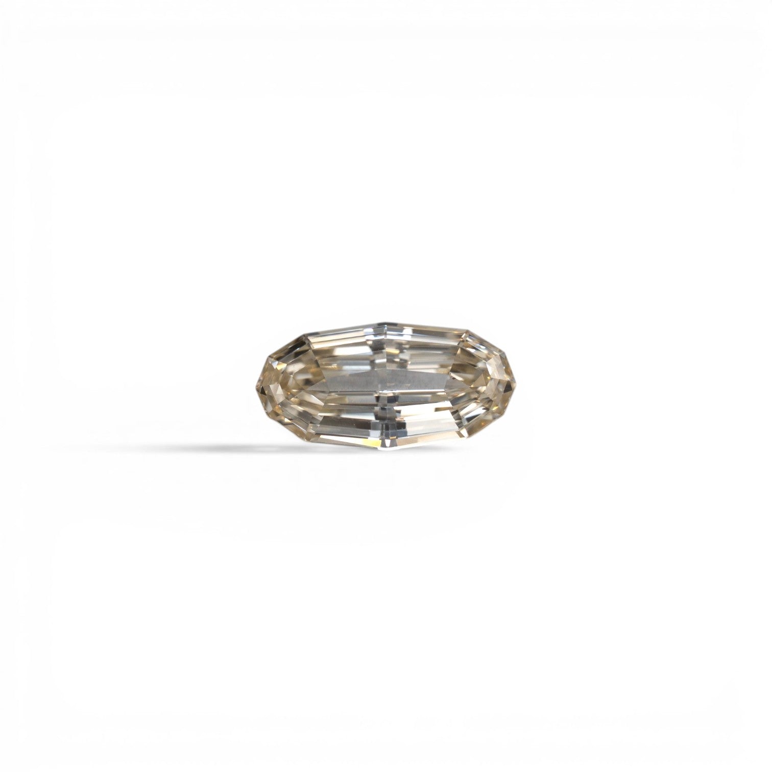 Stórica Studio custom engagement rings in Seattle, 1.01ct geo oval step-cut natural diamond, South Africa origin, champagne QR color, SI1 clarity, with a silvery champagne tone, photographed loose on a white background.