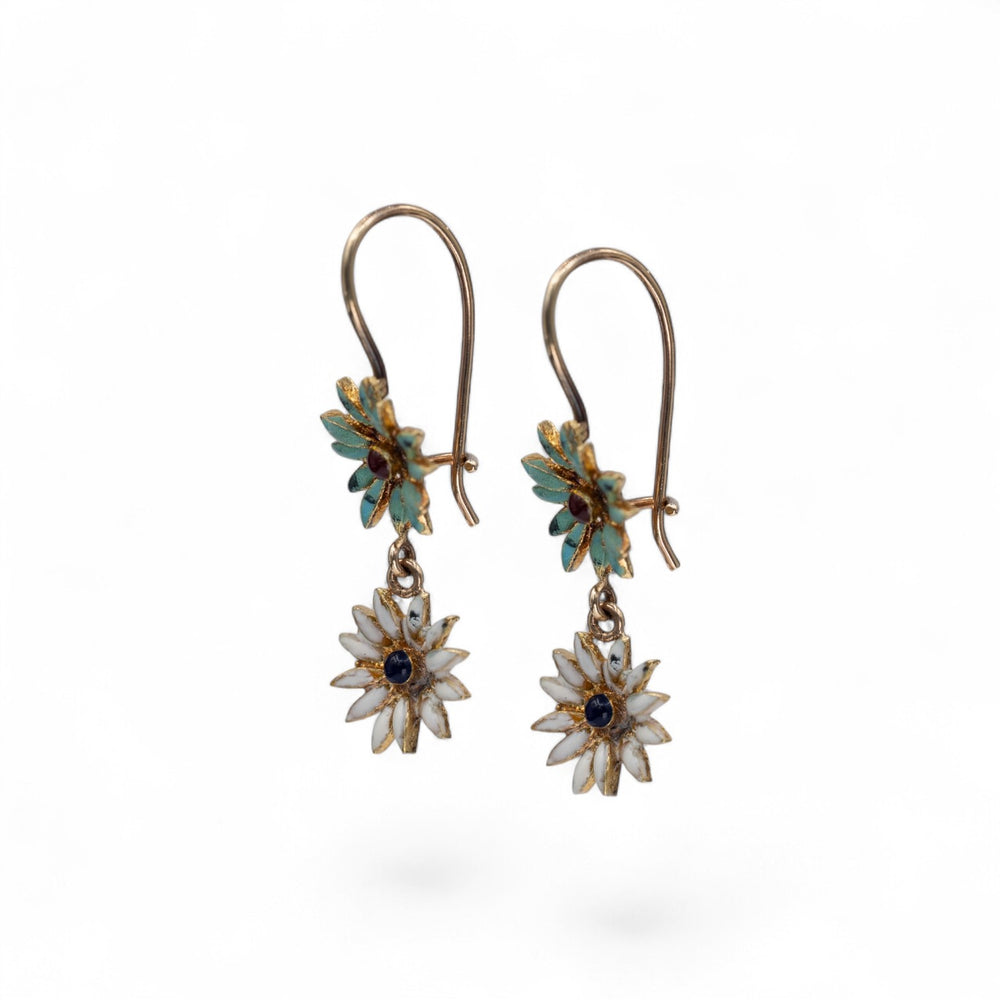 Stórica Studio 18k yellow gold enamel flower drop earrings with white petals and blue center gems.